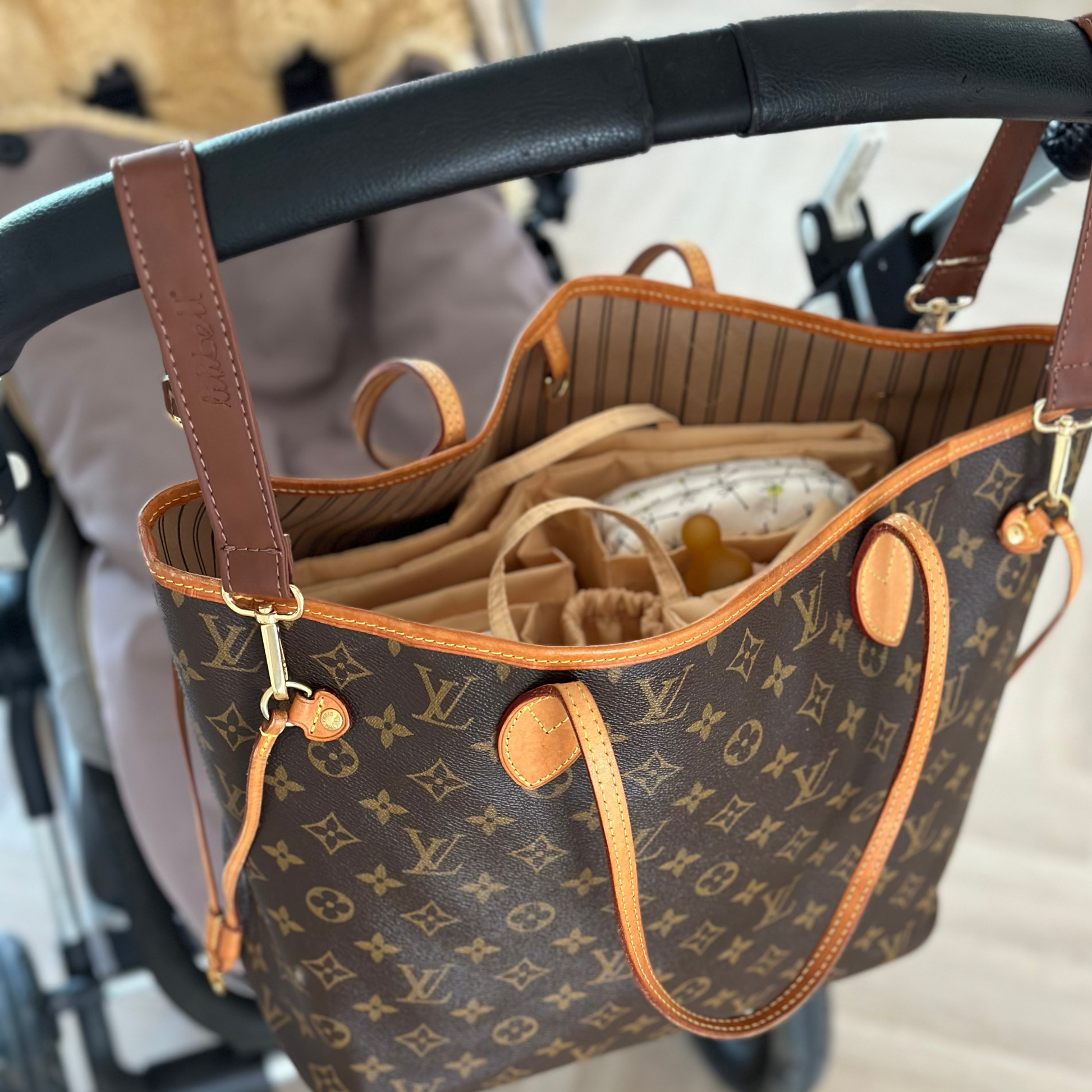 Edle Louis Vuitton Neverfull MM Handtasche, befestigt mit hochwertigen braunen Leder-Kinderwagenhaltern. Perfekt organisiert mit passendem Taschen-Organizer für Wickelutensilien, Schnuller und Babybedarf. Eine stilvolle und praktische Lösung für Mütter unterwegs!
