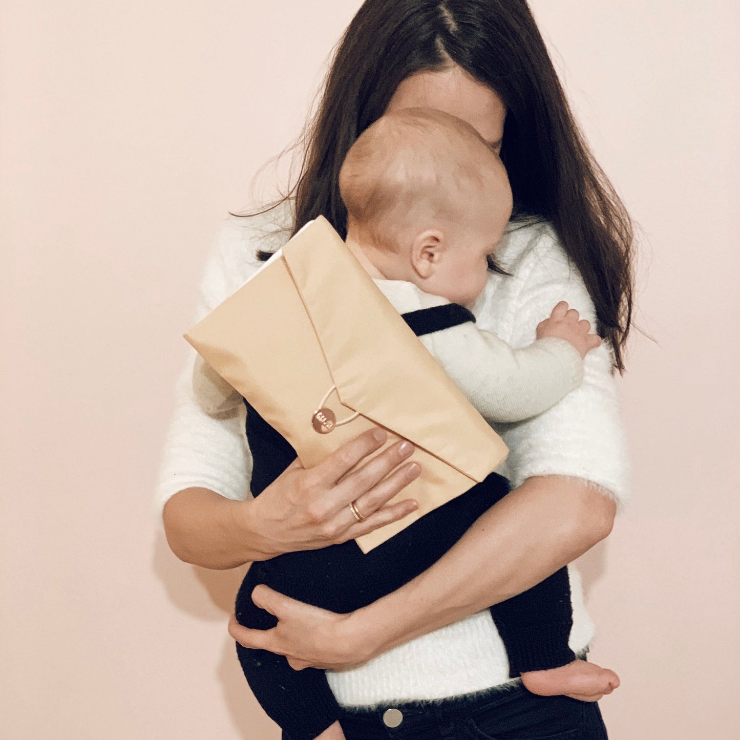 Frau mit Baby im Arm und Daily Daisy Beige in der Hand